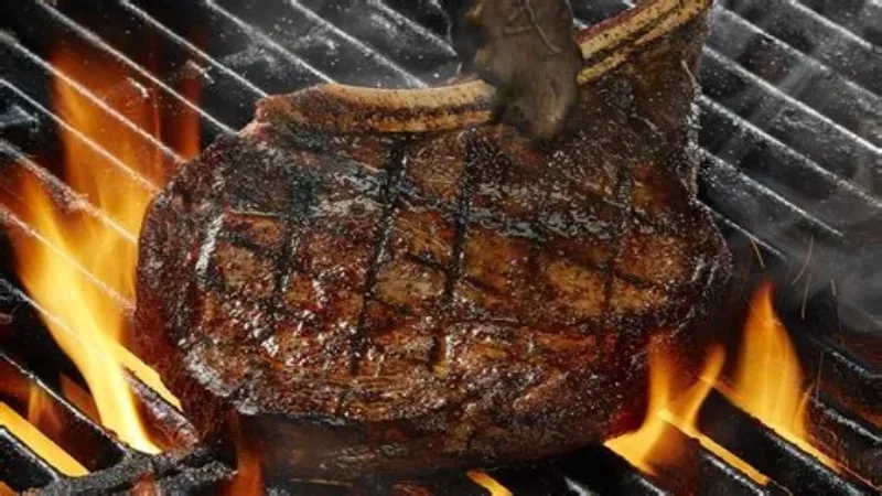 Juicy fire-grilled bone-in Outlaw ribeye steak with herb butter